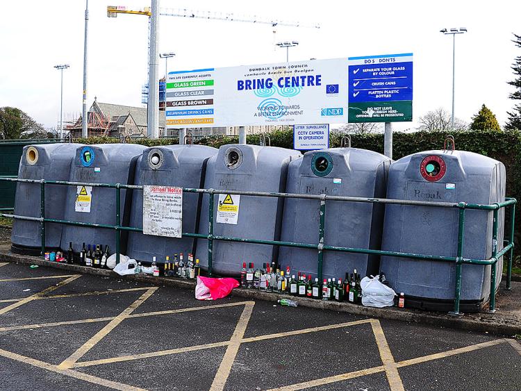 Glass bottles littered around overflowing Dundalk bottle bank