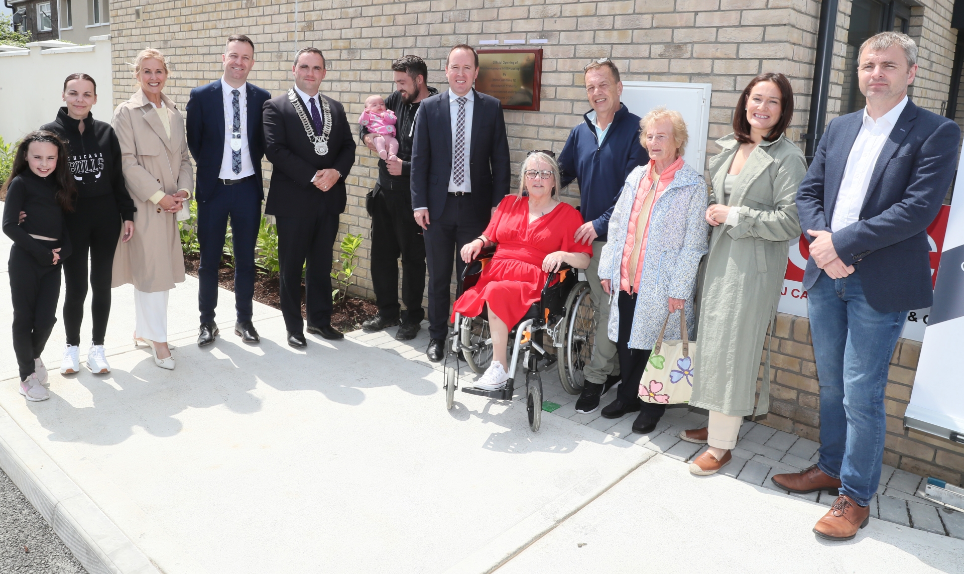 Some of the new residents of the Muirhevnamór Infill Housing Scheme, pictured with John Cummins TD, Minister of State for Local Government and Planning and local public reps (Photo: Paul Connor)