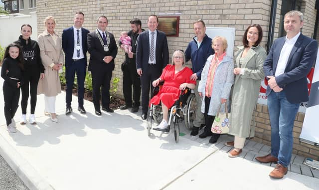 Some of the new residents of the Muirhevnamór Infill Housing Scheme, pictured with John Cummins TD, Minister of State for Local Government and Planning and local public reps (Photo: Paul Connor)