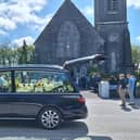 The hearse, with flowers spelling Shay's name, waiting outside St Senan's Church in Clonlara | Picture: Ellen Gough