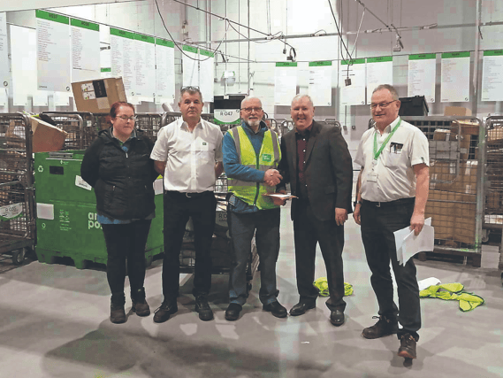 Postal operative Pat McNamara accepts the congratulations of Thomas Hehir, operations manager