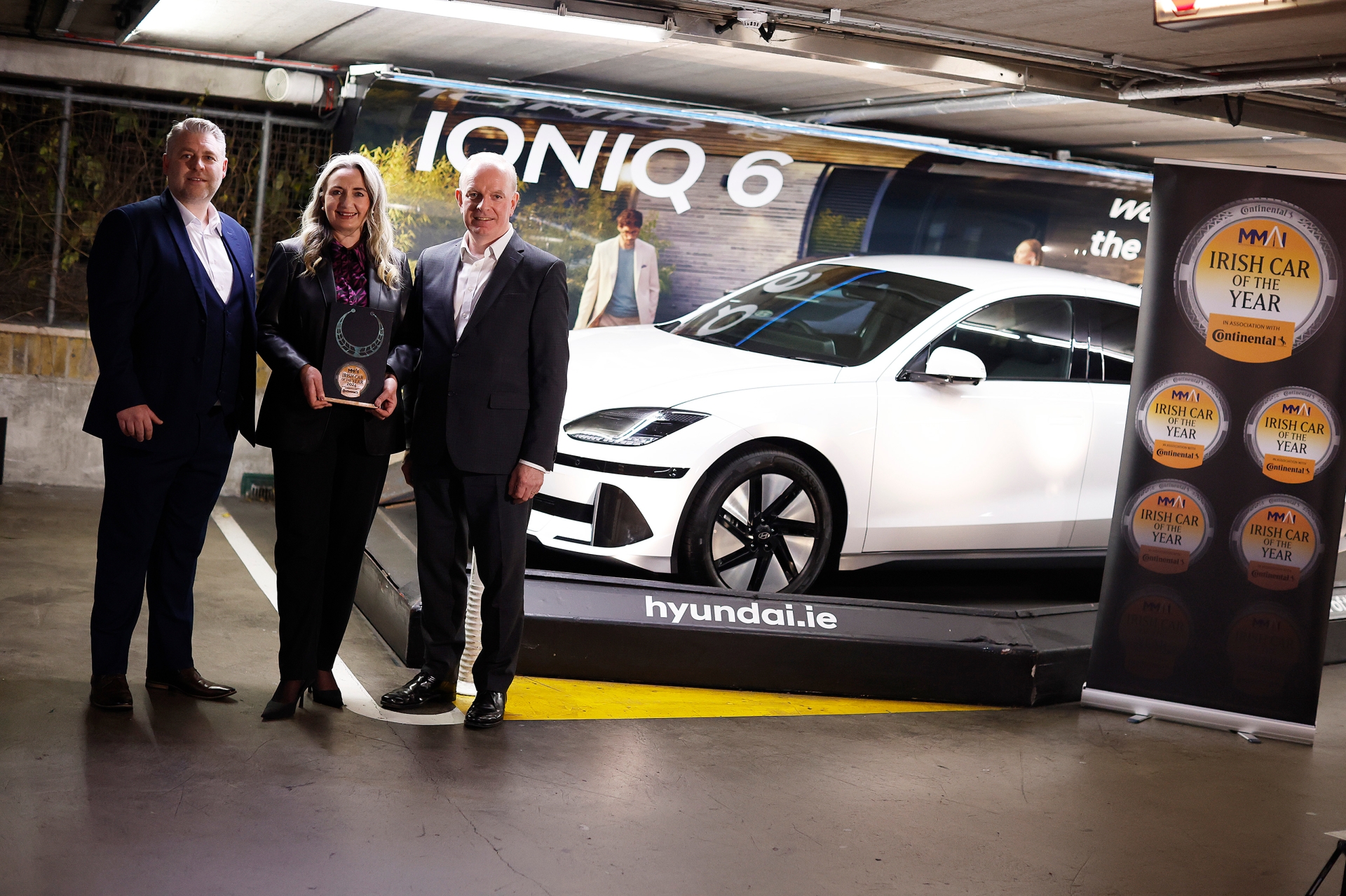 Joe Rayfus, Chairman of the Motoring Media Association of Ireland (MMAI); Sarah Hayes of Hyundai Ireland; Tom Dennigan of awards sponsor, Continental Tyres; with the winning car, the Hyundai IONIQ 6.