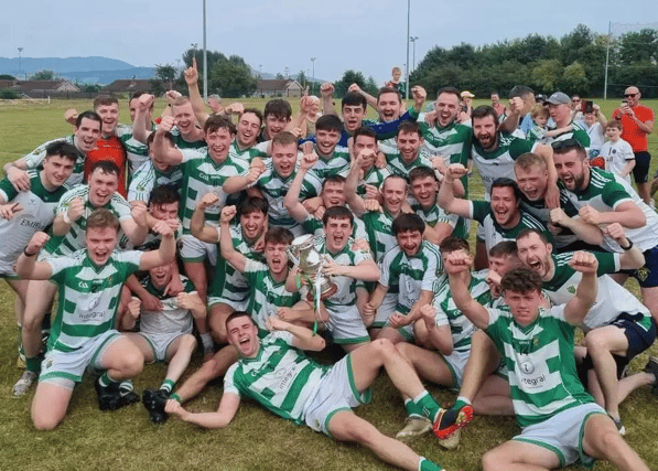 The O Raghallaighs team celebrate with the Div2 trophy after their victory over the Irelanders secured the title