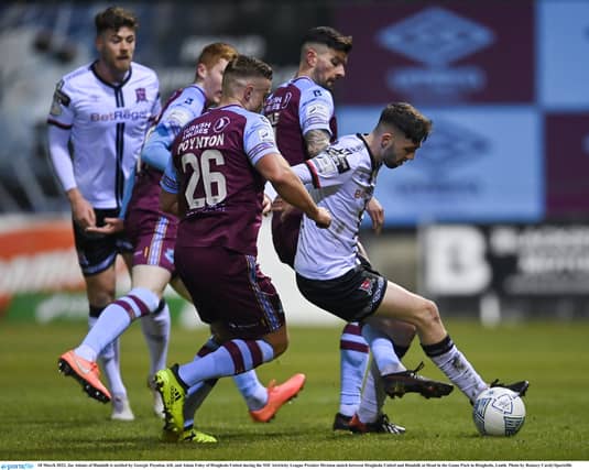 oe Adams of Dundalk is tackled by Georgie Poynton, left, and Adam Foley of Drogheda United. (Pic: Ramsey Cardy/Sportsfile)