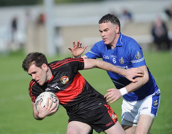 Páraic Smith (Dreadnots) is tackled by Naomh Máirtín's Brendan Reilly. (Pic: Arthur Kinahan)
