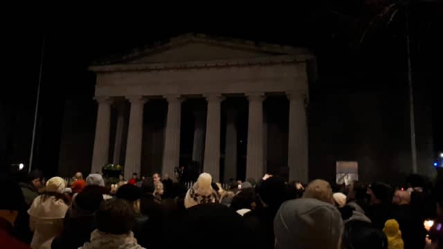 Attendees at the Yosuke Sasaki vigil listen to Lyndsey O'Neill singing John Lennon's 'Imagine'