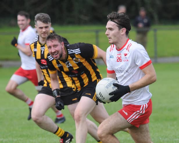 Keith Durnin gets away from  Shane Roddy and James Mahoney of Na Pairsaigh