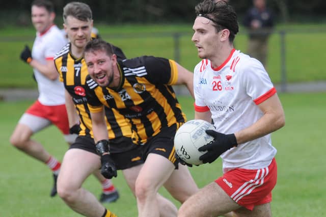 Keith Durnin gets away from Shane Roddy and James Mahoney of Na Pairsaigh