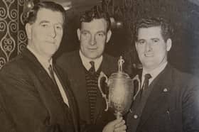 Dickie Kieran is presented with the Macardle Cup by County Board chairman, Seán Murray, with in centre, Nick Mackin. St Kevin's won the trophy three years in succession in the 1960s