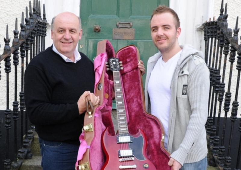 Tony Moran  Avenue Road giving his returned stolen guitar to Paddy McGurk  Music teacher at the Apple Tree  foundation  house in Roden Place